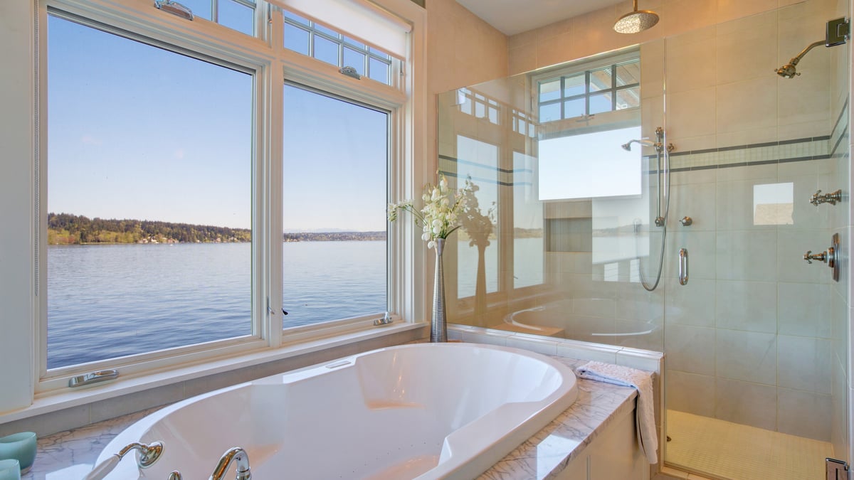 Bright bathroom with a frameless glass shower beside a soaking tub